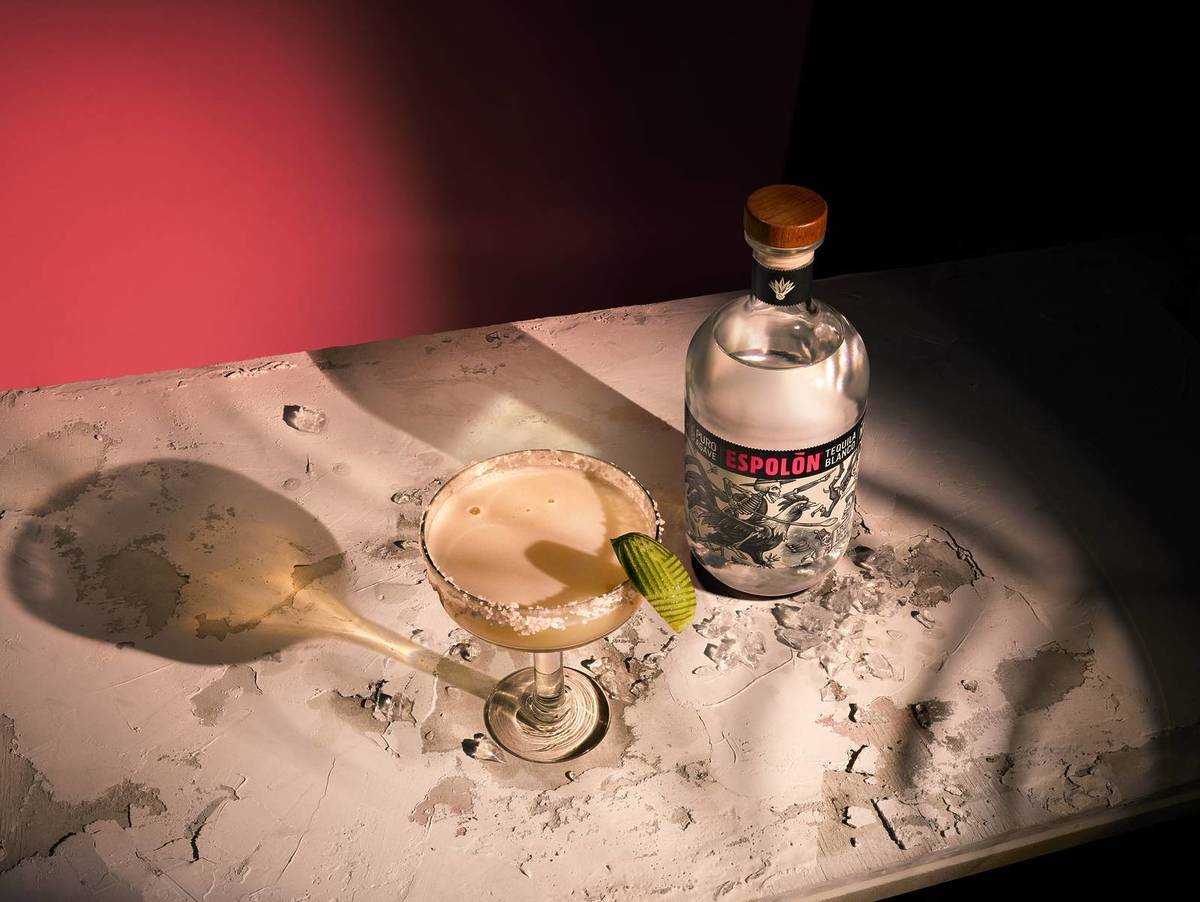 a bottle of espolon tequila next to a margarita in a coupe glass