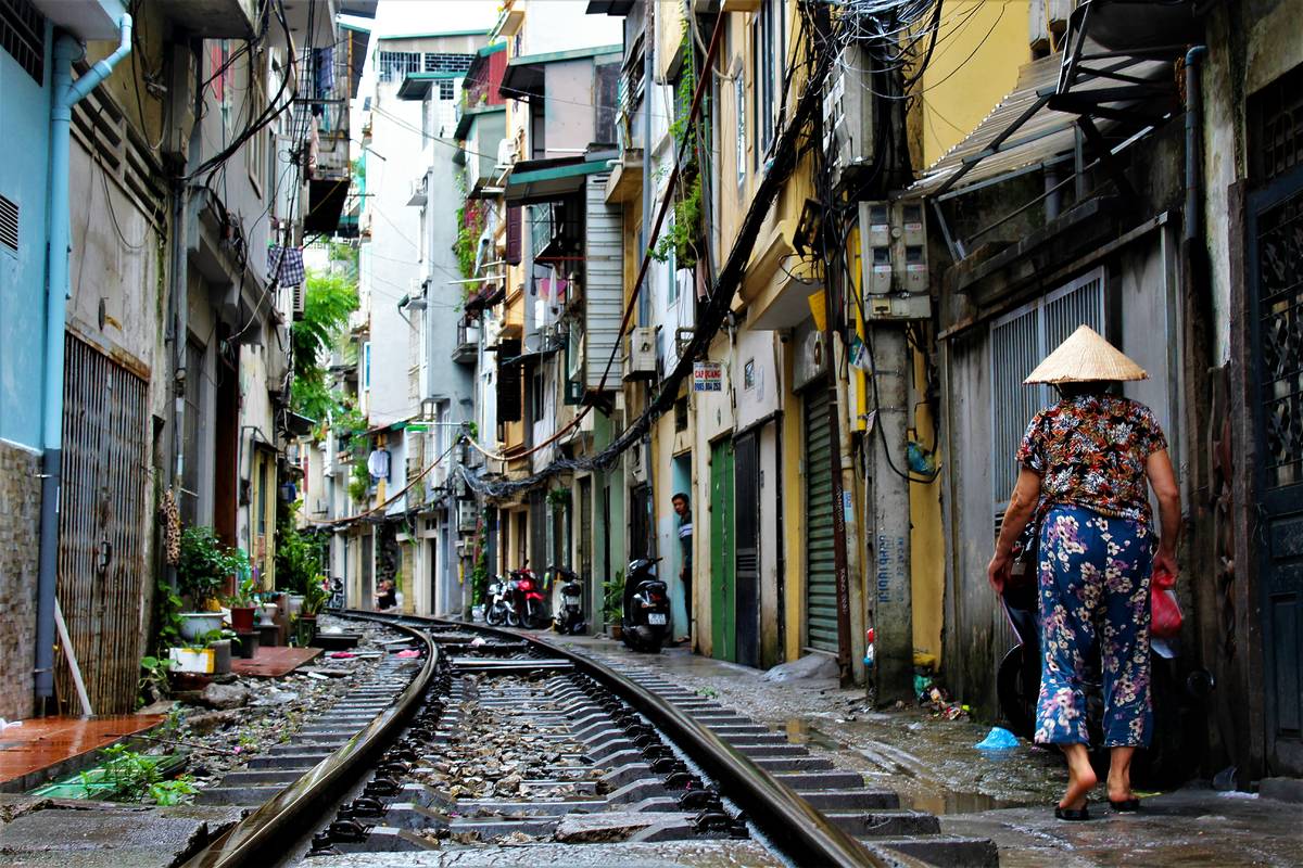 A small street lined with colourful doors with a train track running next to the houses