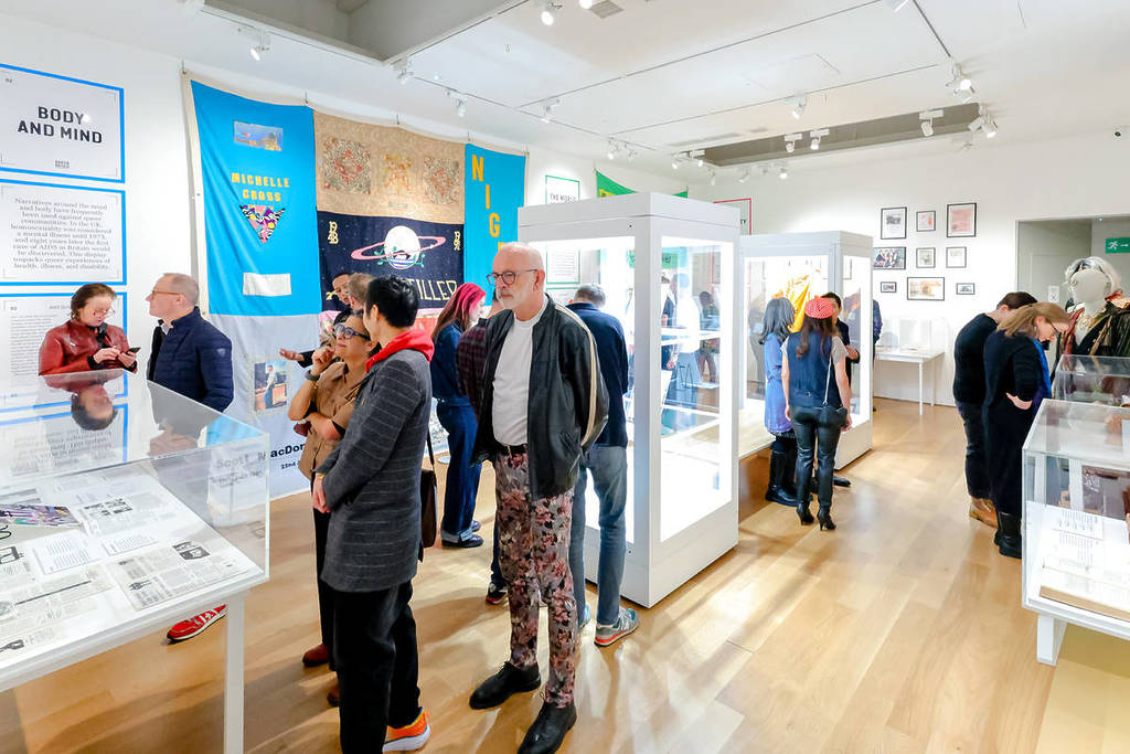 Menschen, die durch das Queer Britain Museum wandern und sich die Ausstellungsstücke ansehen