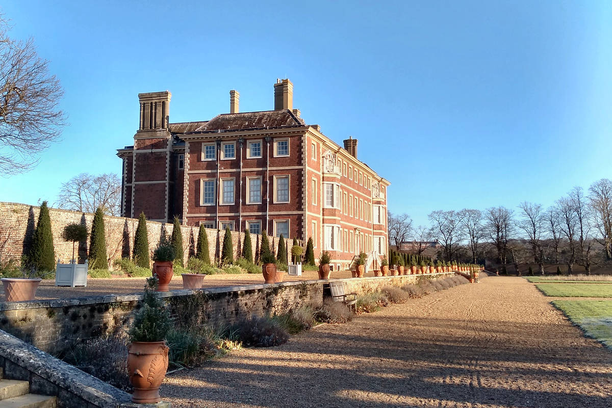 Ham House and some of its surrounded land under a bright blue sky
