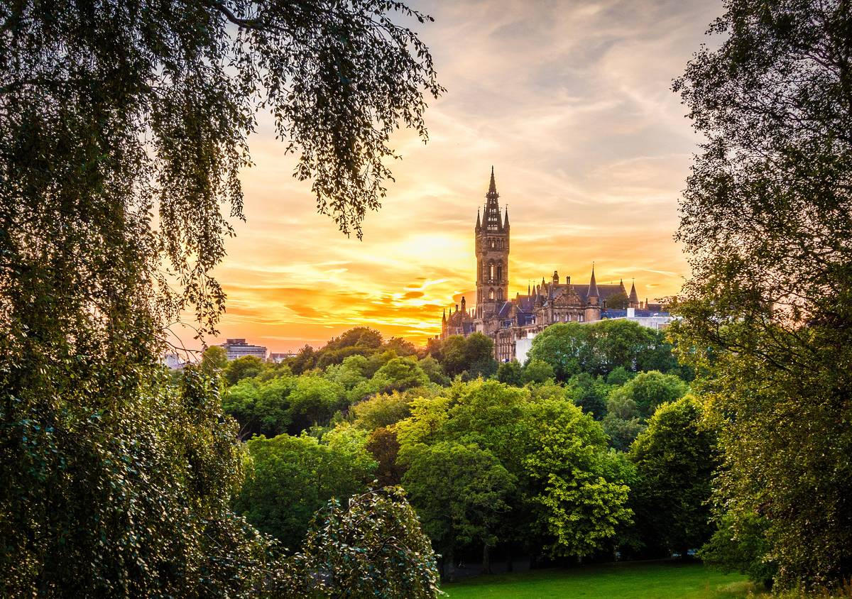 Glasgow university from across a park at sunset
