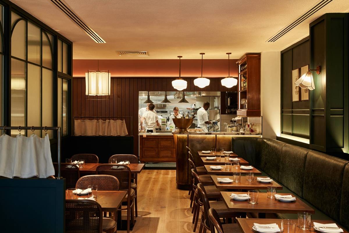 the inteior of 64 goodge street restaurant, with an open kitchen in the back revealing chefs and cooks working away