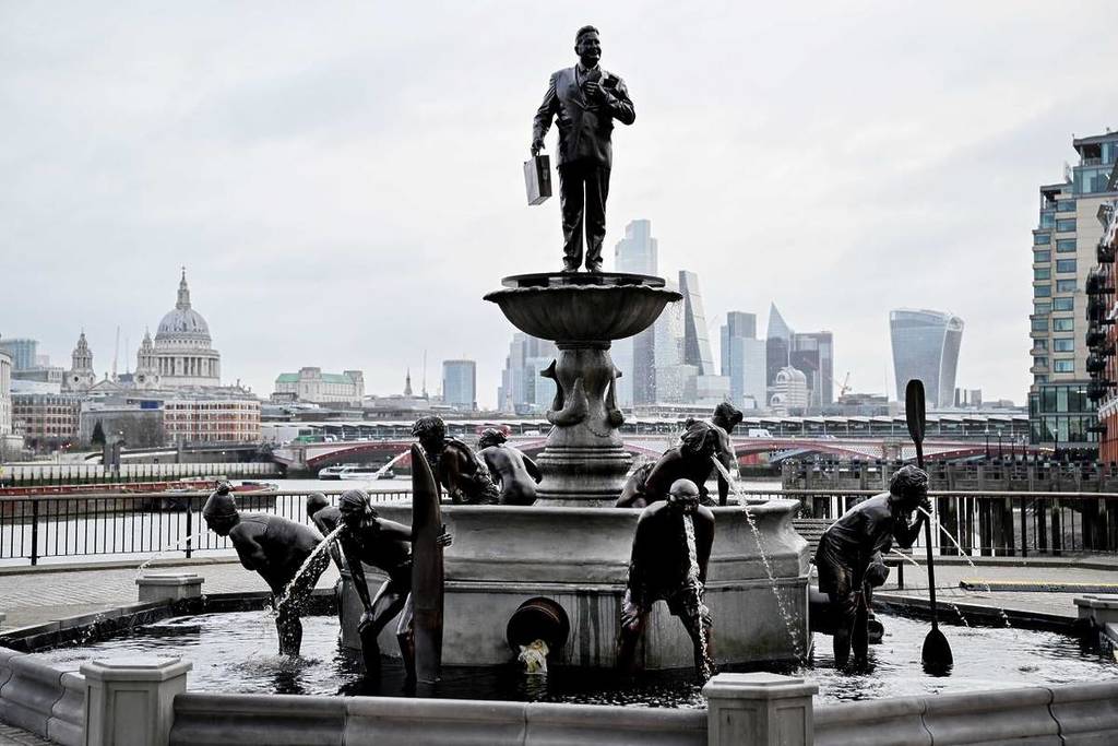 une fontaine avec des statues de personnes penchées en avant « vomissant » de l'eau sale par la bouche