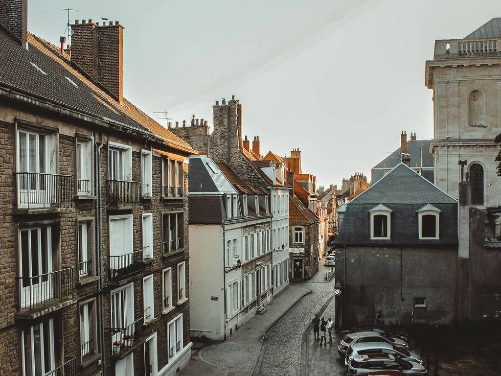 a cobbled street and cars parked in France