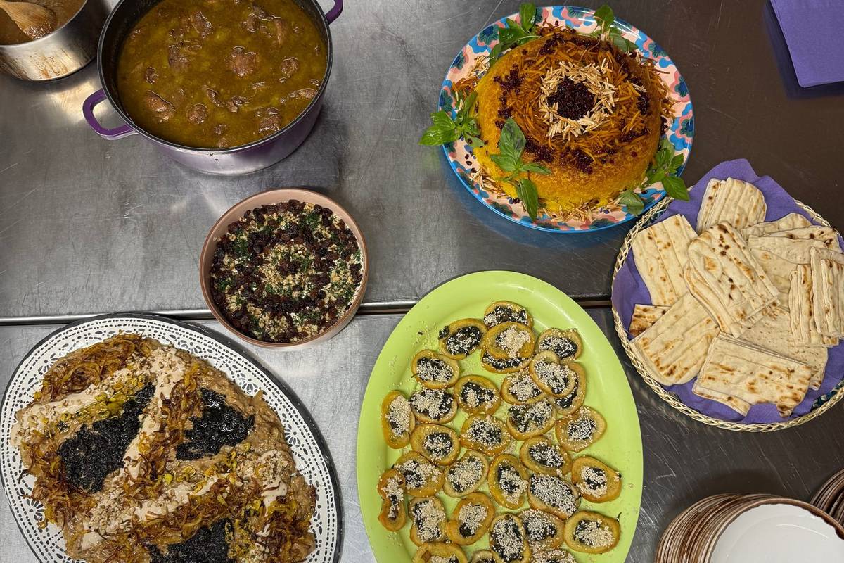 A shot from above the table with lots of colourful Iranian dishes laid out on plates
