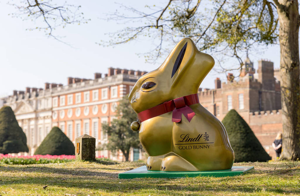 a large statue of a lindt gold bunny in the grounds of hampton court palace