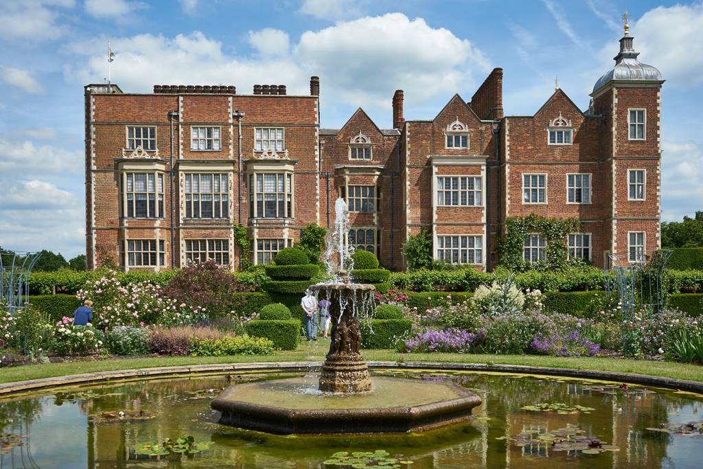 Hatfield House und sein Spiegelbild in einem Gartenbrunnen
