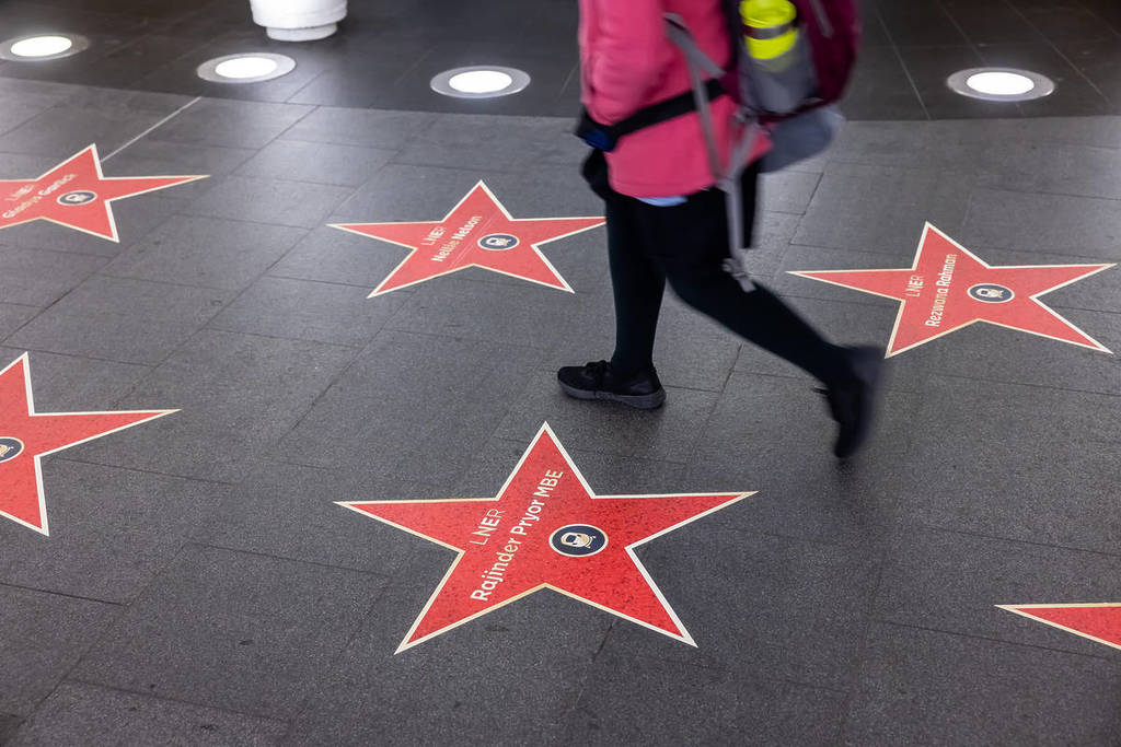 alguém a passar por uma estrela numa trilha de estrelas que celebra a história feminina desconhecida dos caminhos de ferro