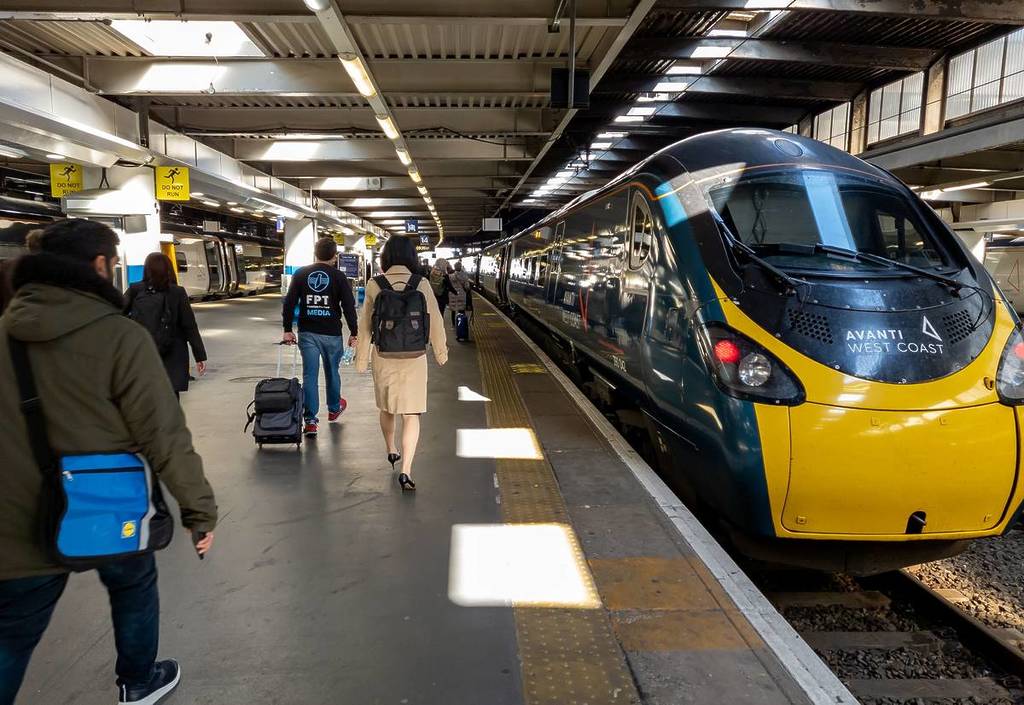 passengers walking along the platform at Euston next to an Avanti West Coast train