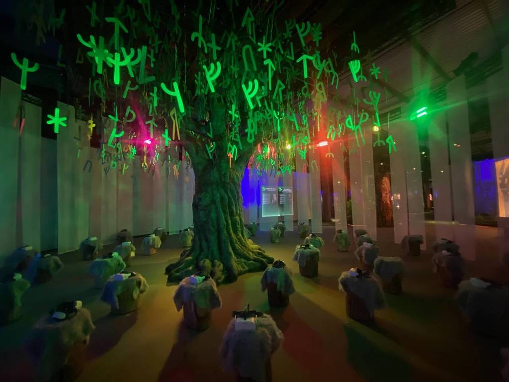 la reconstitution de l'arbre Yggdrasil, entouré de souches d'arbres surmontées de casques de réalité virtuelle, à Vikings : The Immersive Experience