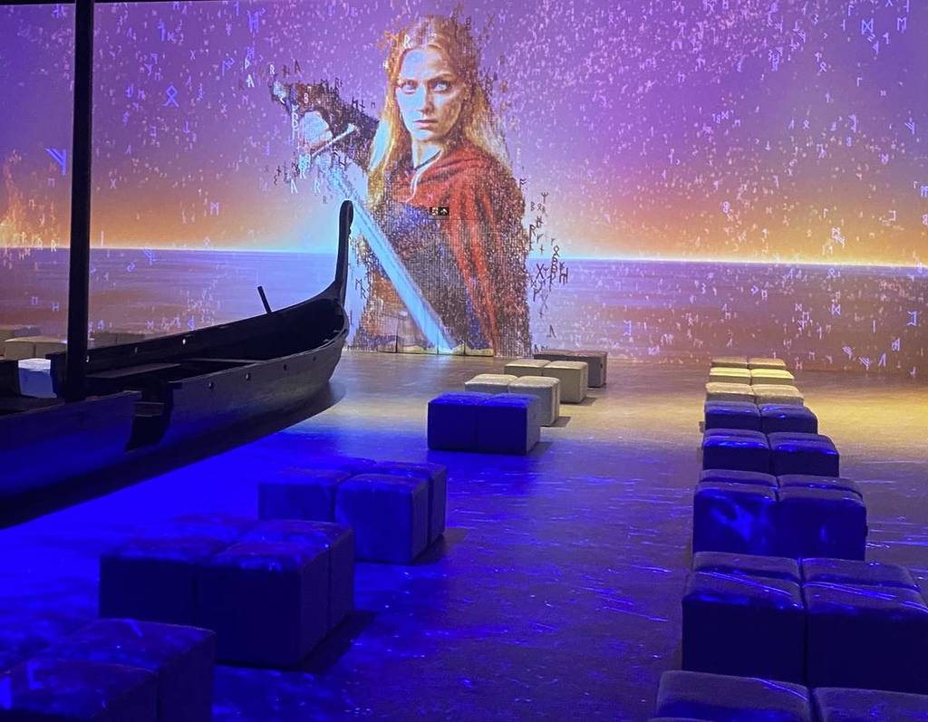 a digital image Queen Kraka prepares to pull her sword in the 36-degree room at Vikings: The Immersive Experience