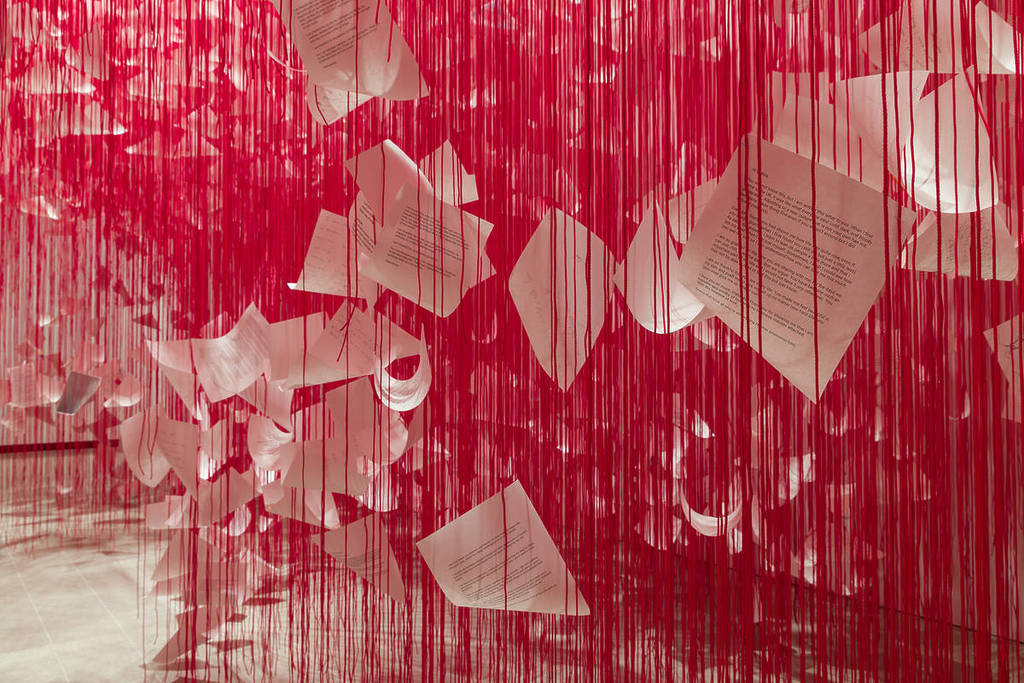 letters suspended in the air from red threads