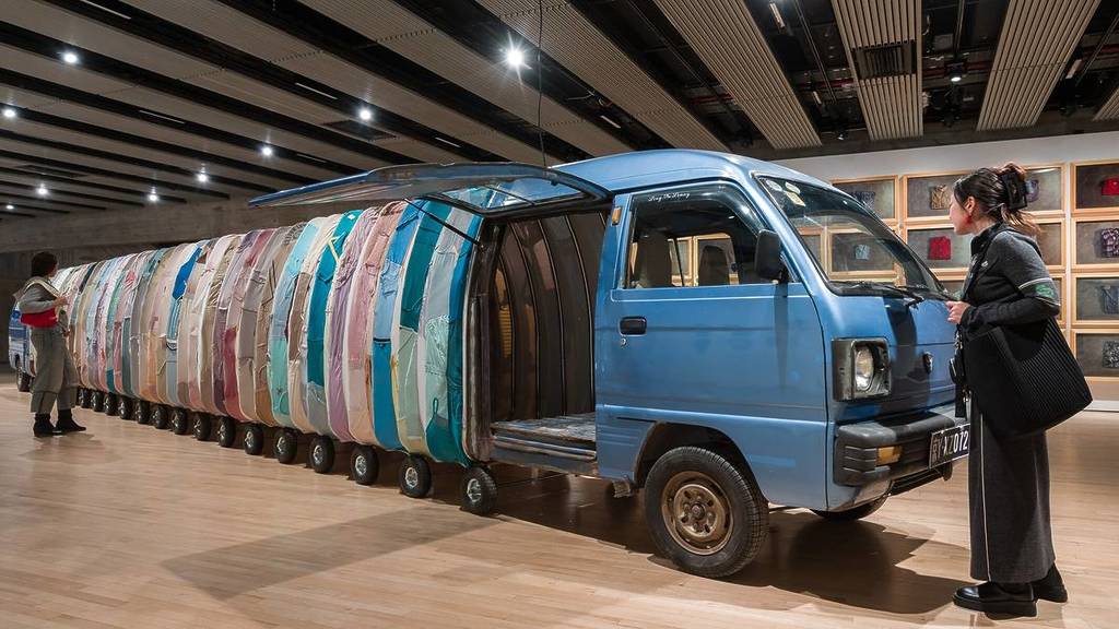 a small truck whose body has been extended with a car body made from recycled clothing