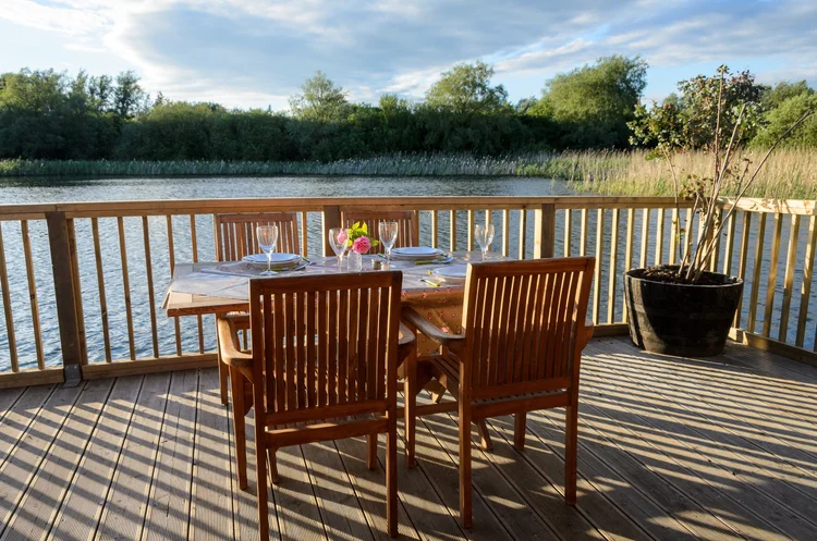 twee stoelen op een terras met uitzicht over een meer