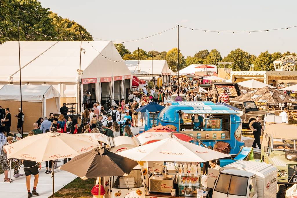 crowds of people milling about various tents and food stands at a food festival
