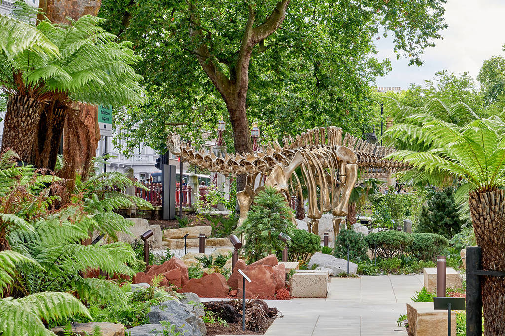 a dinosaur skeleton amongst the greenery at the natural history museum gardens