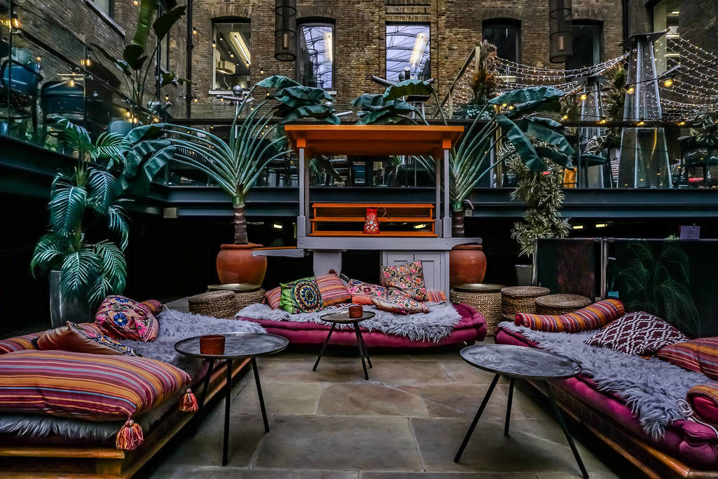 das Interieur eines Restaurants der Cinnamon-Kette mit bequemen, sofaähnlichen Sitzgelegenheiten und niedrigen Tischen