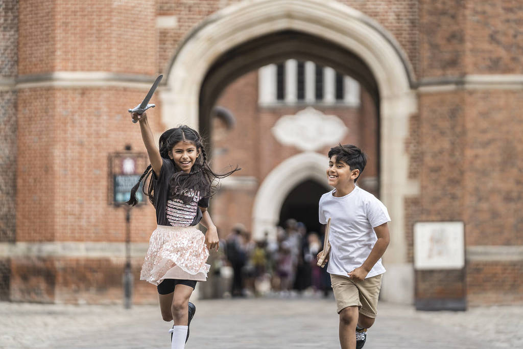 two children running around hampton court palace