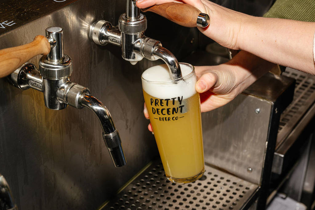 una pinta de cerveza servida desde un grifo lateral en un vaso de marca «bastante decente»