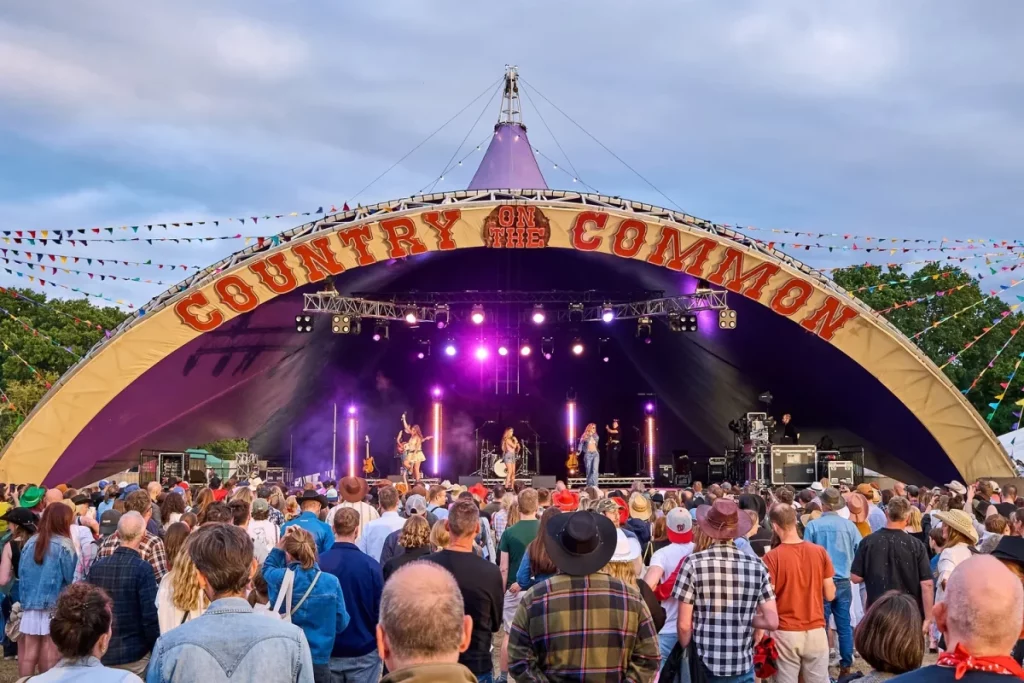 Eine Menschenmenge schaut einem Country-Musik-Act auf einer großen Bühne in einem Londoner Park zu