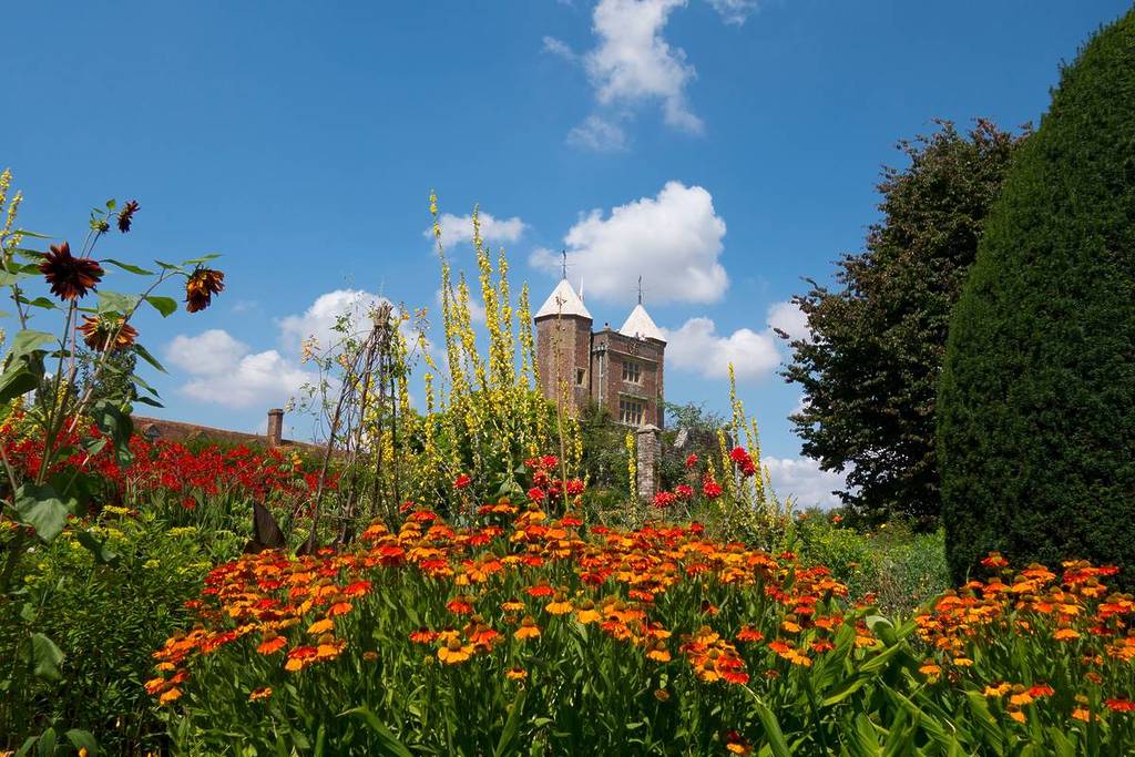 Eine Vielzahl bunter Blumen mit Blick auf das Schloss Sissinghurt im Hintergrund