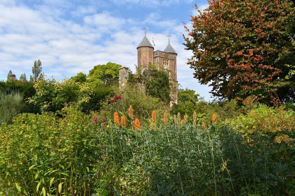Een historisch kasteel verscholen achter gras en wilde bloemen