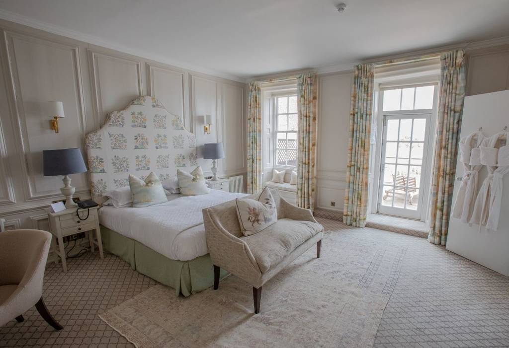 Um quarto de hotel luxuoso decorado em tons neutros