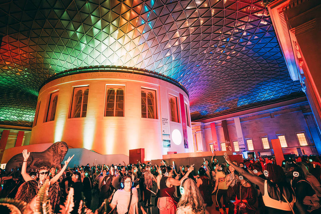 Het interieur van de Great Court van het British Museum, verlicht en vol met mensen voor een silent disco