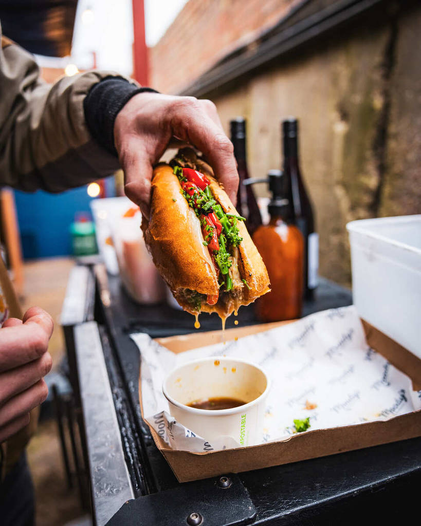 un hot-dog juteux qui vient d’être trempé dans un pot de sauce