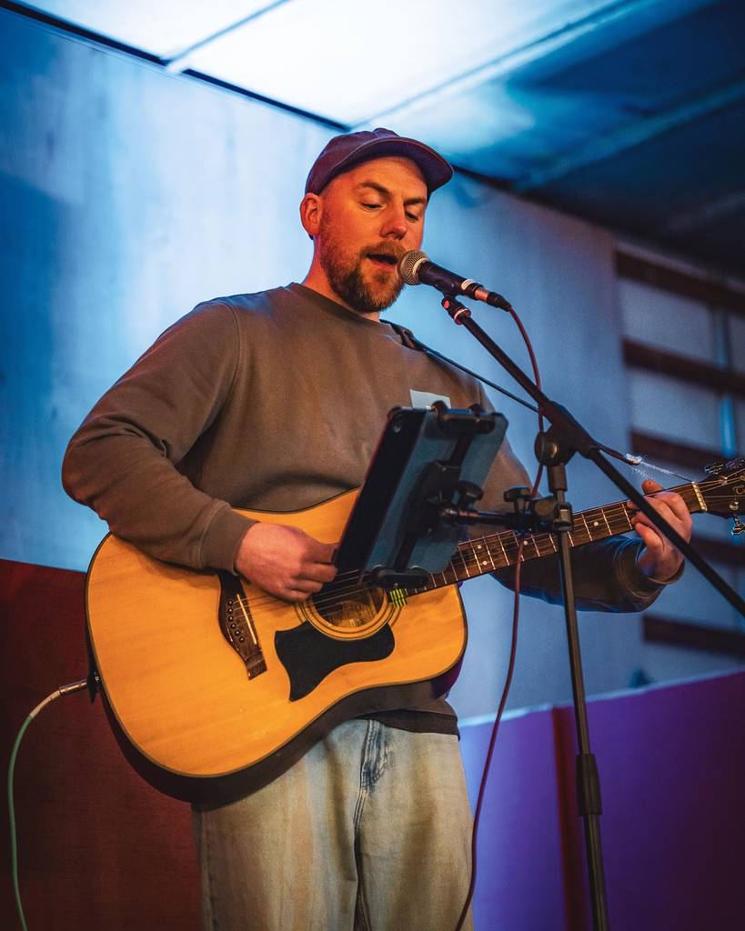 un musicien qui joue de la guitare et chante