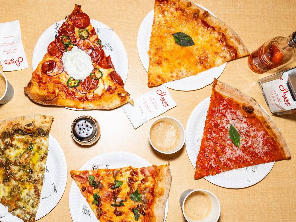 slices of pizza on paper plates on a table seen from above
