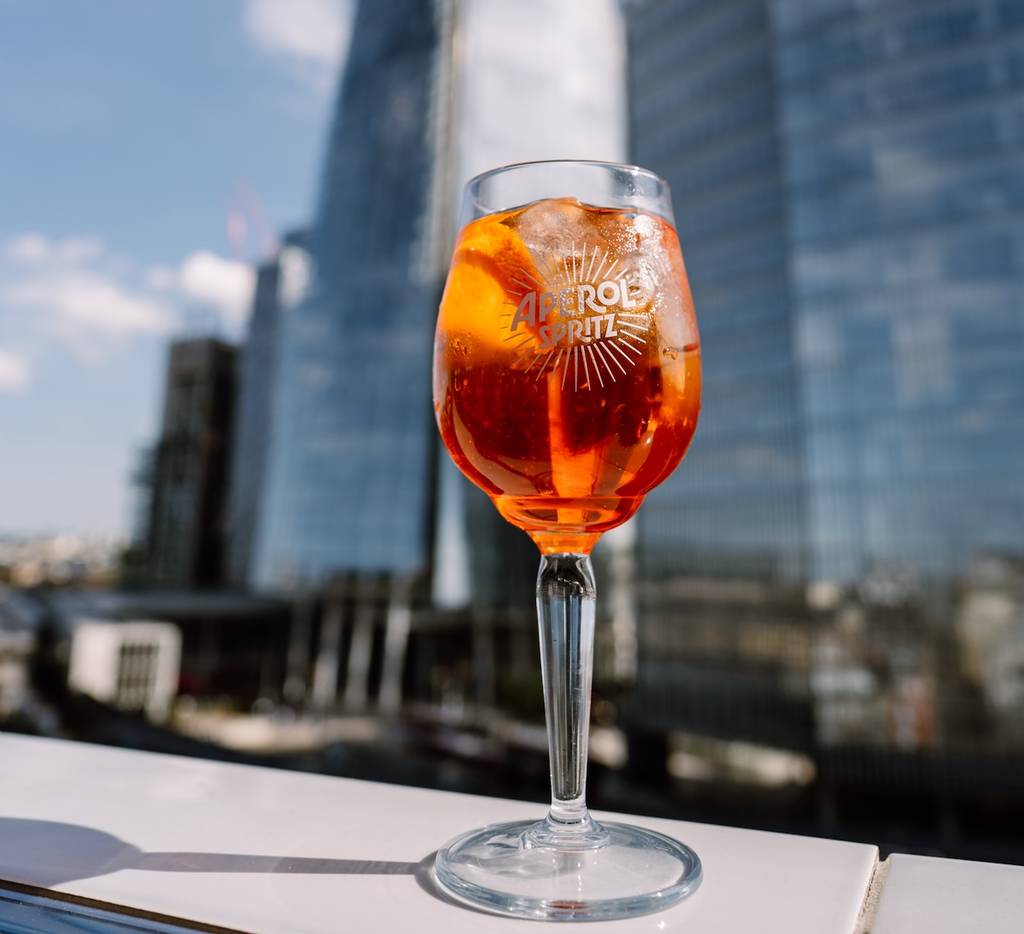 an aperol spritz resting on a rooftop terrace ledge in london bridge