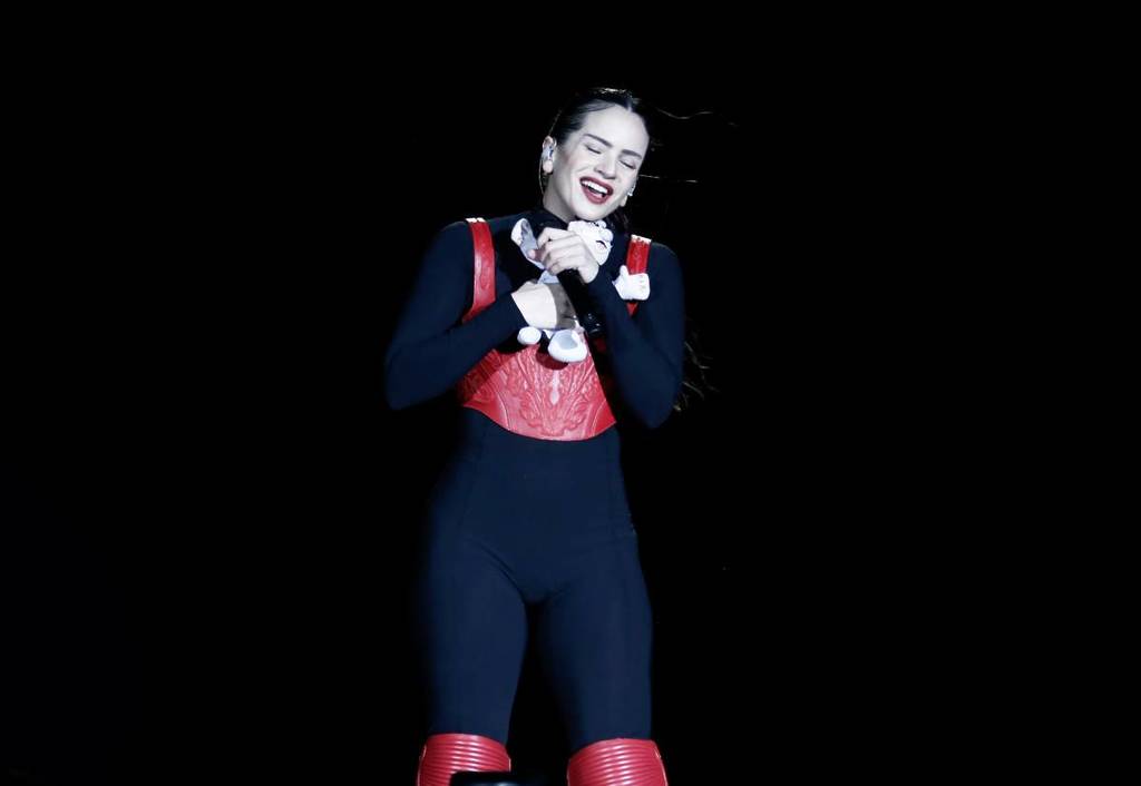Rosalía sur scène au Mexique, vêtue d’un costume rouge et noir