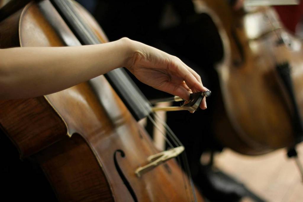 Gros plan sur un violoncelliste jouant lors d’un concert de musique classique
