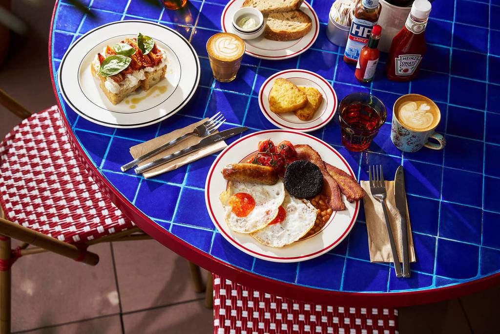 una varietà di piatti da brunch su un tavolo con piastrelle blu