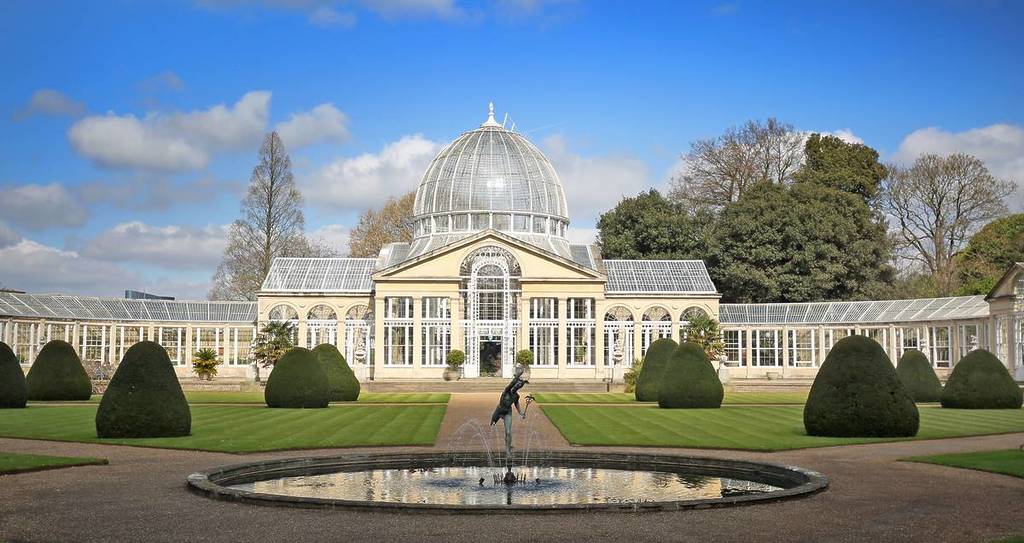 Syon Großes Glashaus mit einem leuchtend blauen Himmel in angelegten Gärten