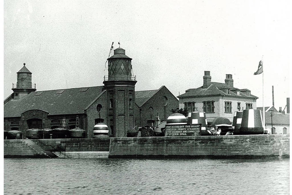 an old black and white photo of Trinity Buoy Wharf, showing two lighthouses poking out of the main building