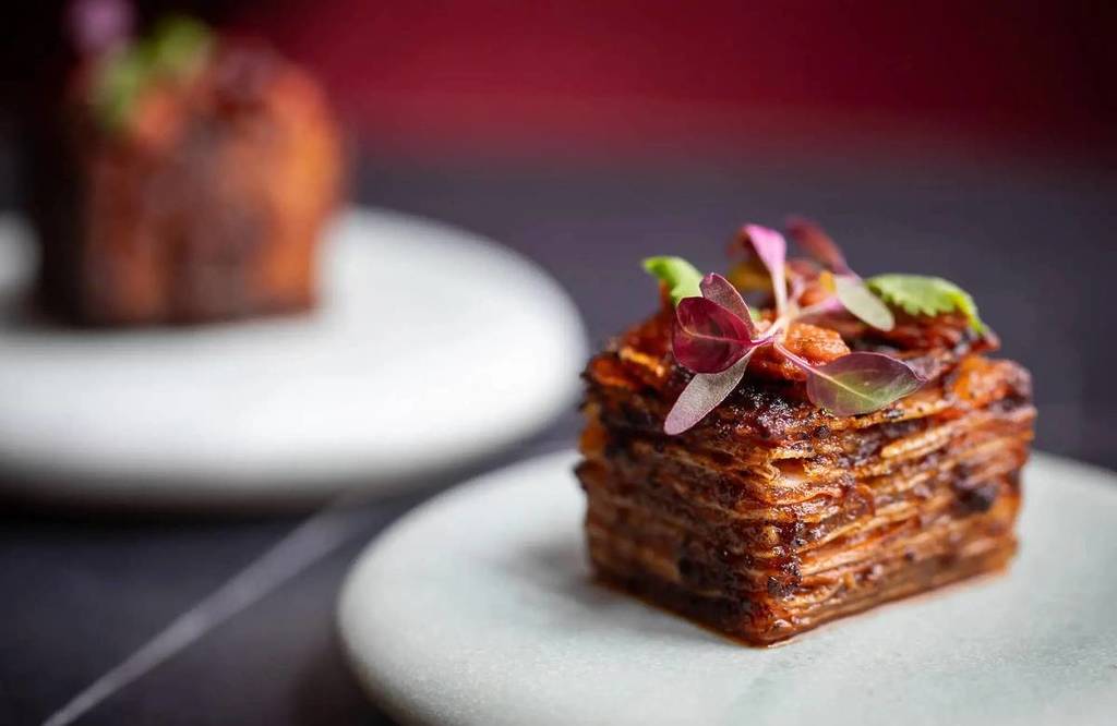 ein Teller mit gestapelten Speisen, der einer zarten Scheibe Lasagne ähnelt
