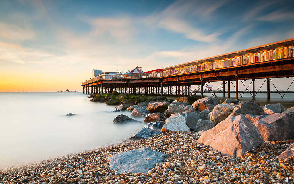 Una colorida imagen del muelle de Herne Bay tomada al atardecer que lleva la mirada hacia el viejo muelle en desuso en el mar