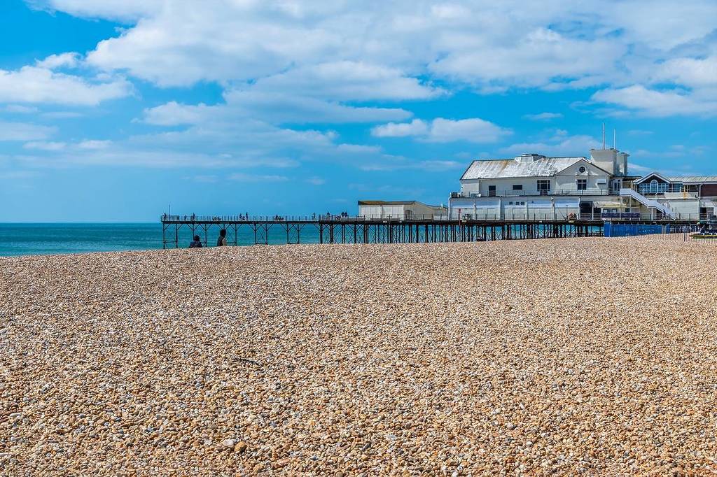 Ein Blick über den Strand in Richtung Pier in Bognor Regis, Sussex im Sommer
