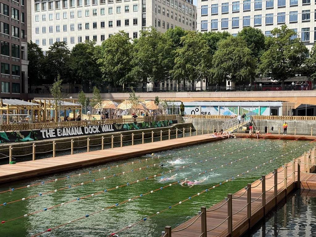 una piscina al aire libre flotante en Canary Wharf, rodeada de rascacielos que se alzan a su alrededor