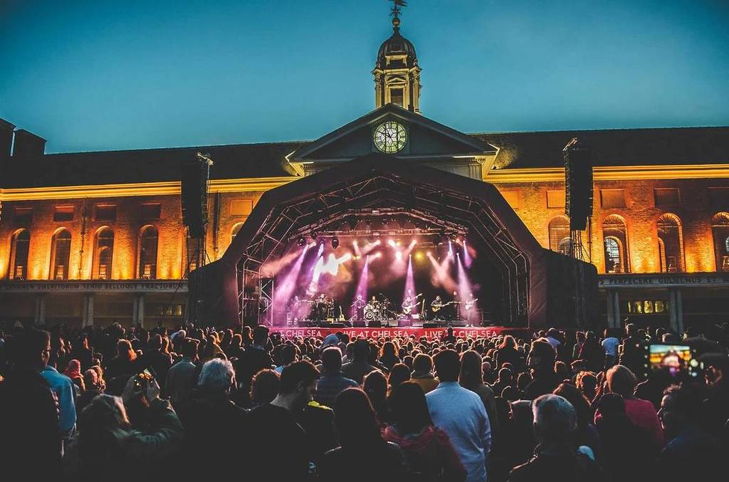um grande público num concerto ao ar livre com um grande palco em frente ao Royal Hospital Chelsea
