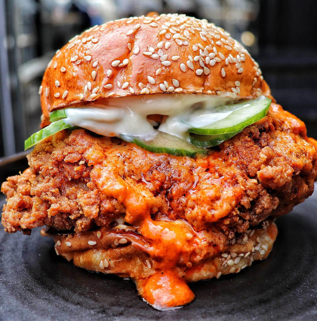 un burger au poulet frit débordant de sauce