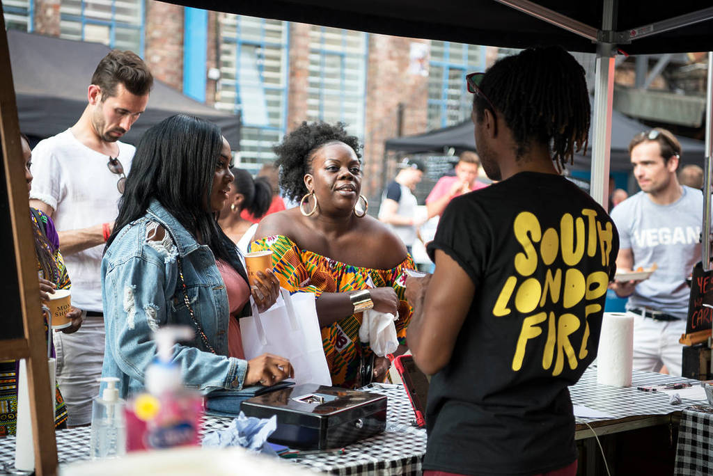 de gens qui attendent leur repas devant un stand de cuisine de rue