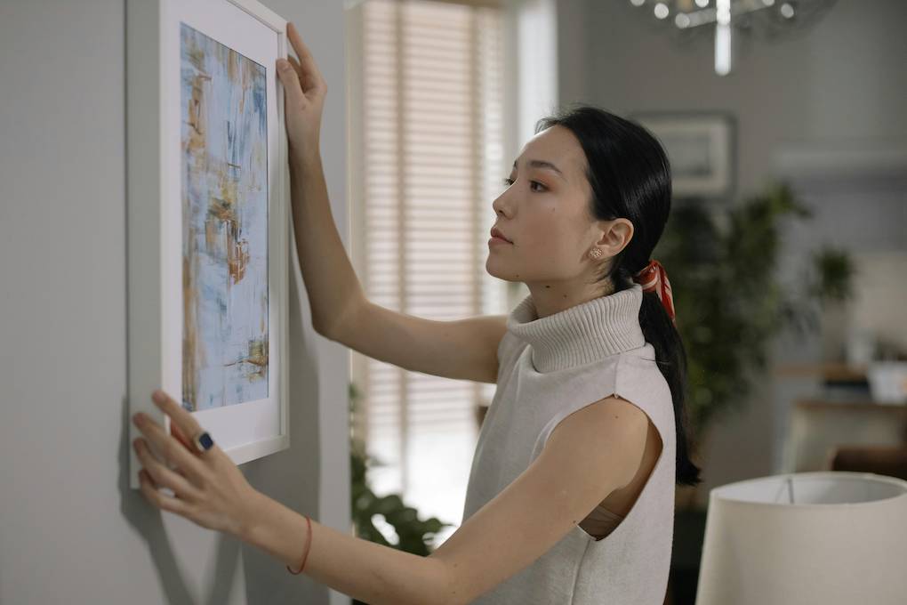 woman hanging photo up