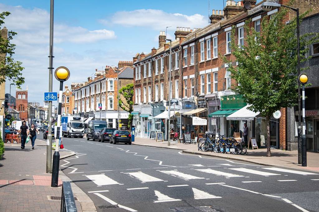 Eine Straße in London mit vielen Geschäften und Cafés