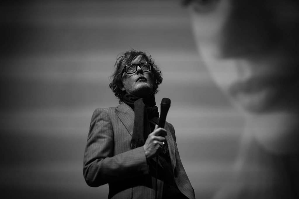 Jarvis Cocker bei einem Live-Auftritt mit einem Mikrofon in der Hand