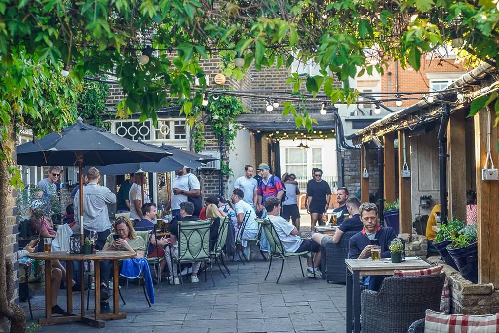 Een biertuin met kleine hoekjes en heel veel tafels