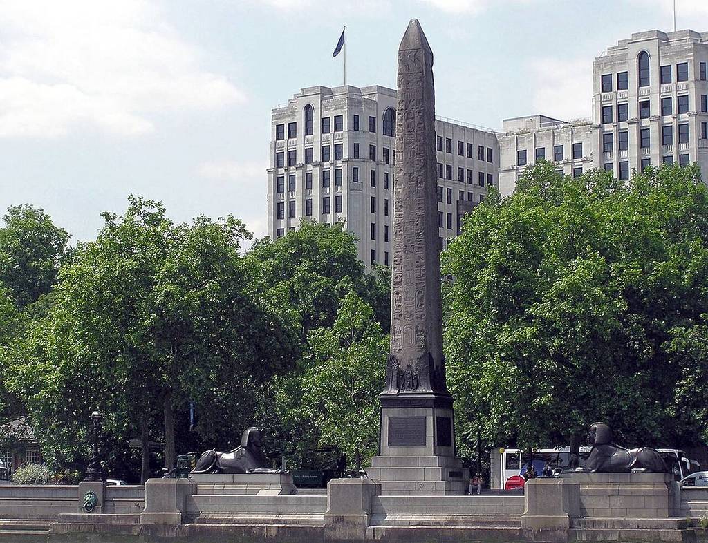 a pointed obelisk, carved with inscriptions, known as Cleopatra's Needle, with sphinx sculptures next to it, as seen from the River Thames