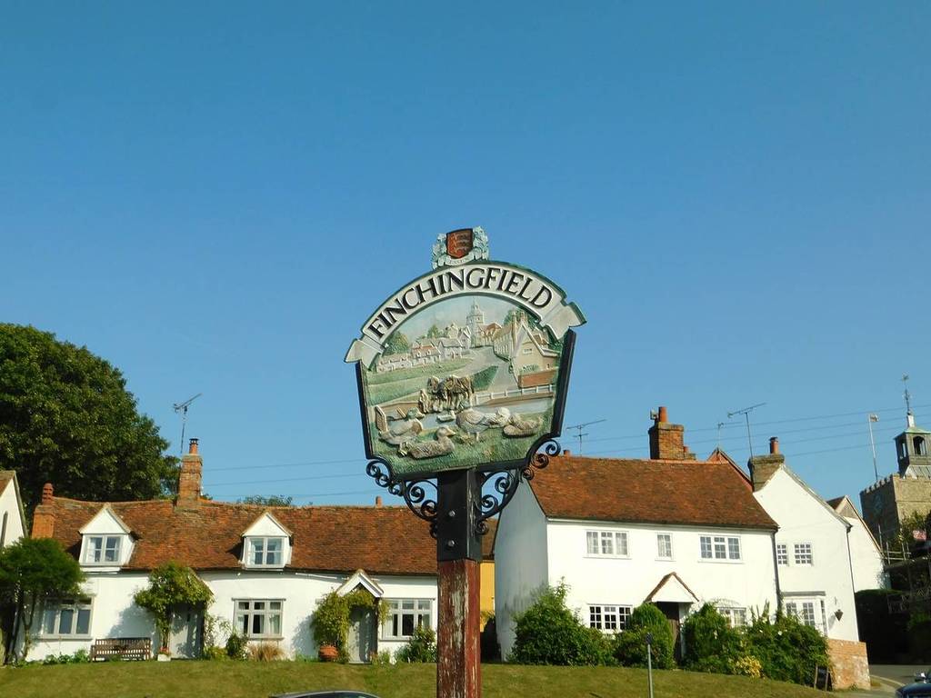 Das Ortsschild von Finchingfield, im Hintergrund die historischen Häuser und die Dorfkirche
